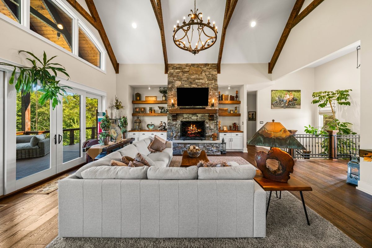 Living room with stone fireplace and vaulted timber beams at 12423 Hickory Creek Rd, Knoxville TN