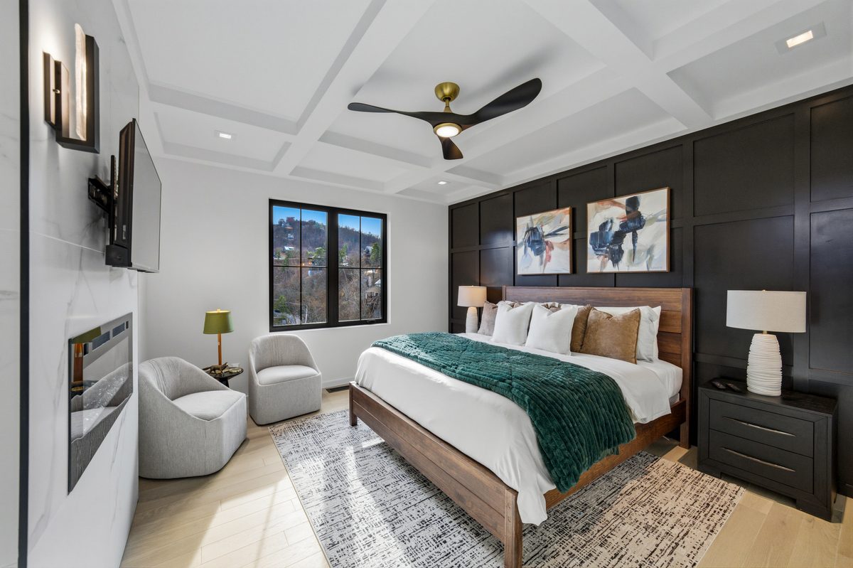 Bedroom with coffered ceiling, dark accent wall and green throw at 550 Greenbriar Ln, Gatlinburg TN