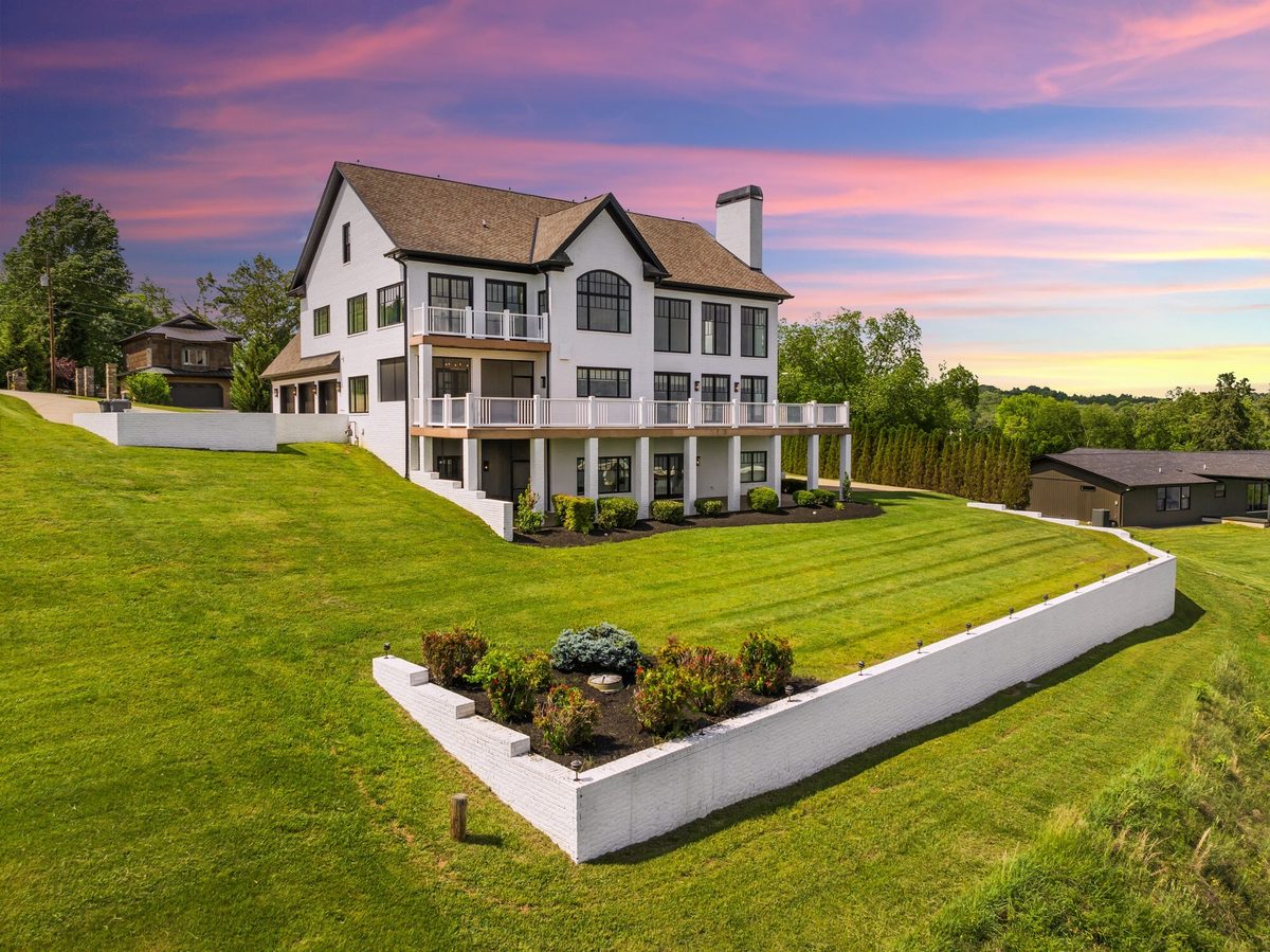 Twilight aerial view of a large white home above a terraced lawn under a pink and purple sky, Dandridge TN