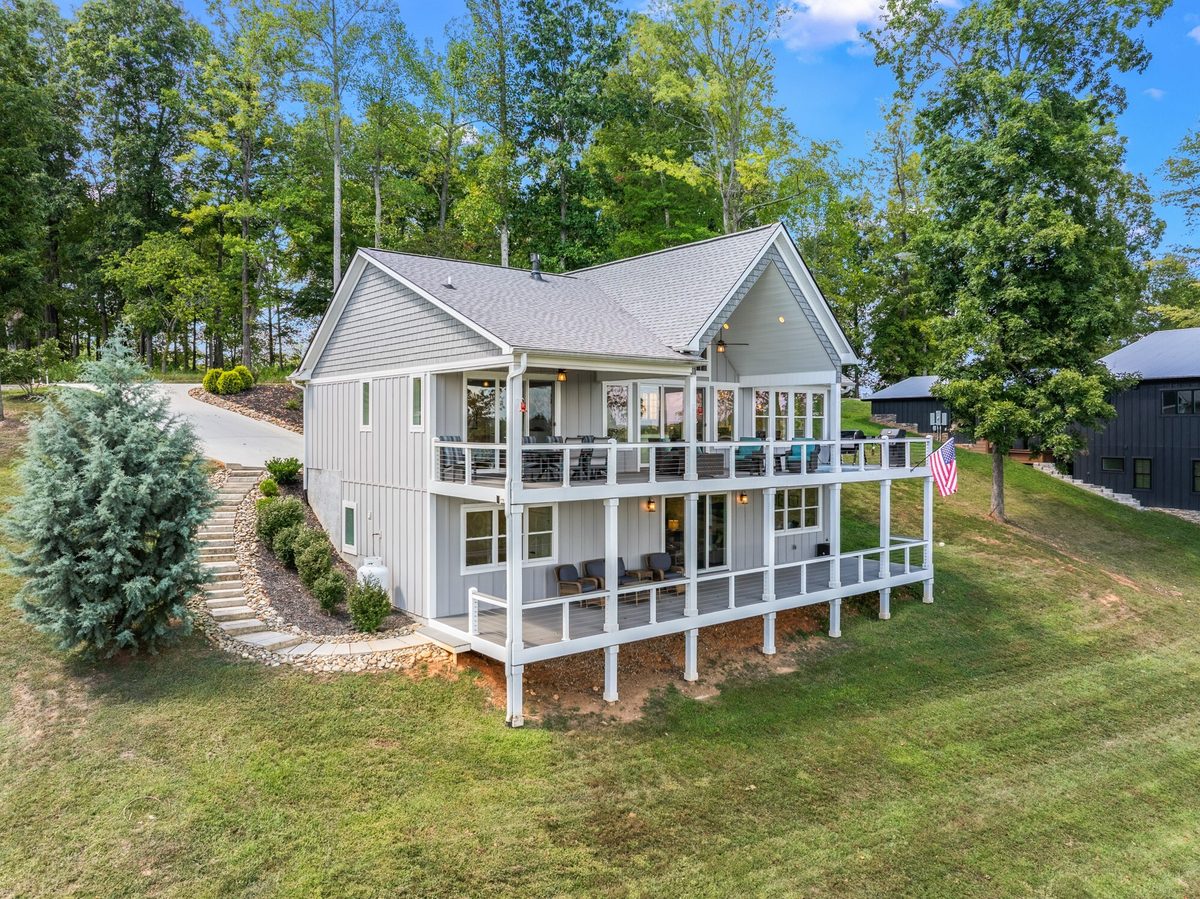 Aerial view of a white two story home with covered decks on both levels and a sloping lawn, LaFollette TN