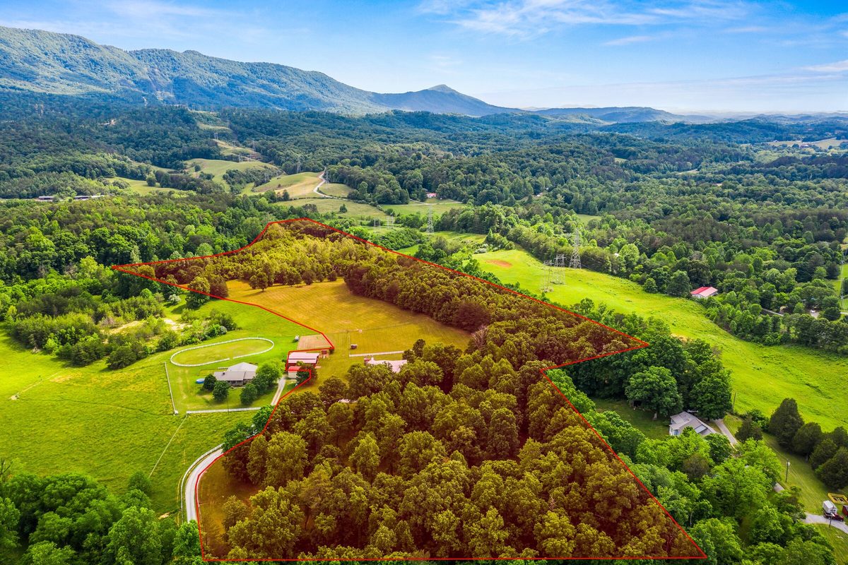 Aerial view of wooded and open acreage outlined in red below mountain peaks, Maryville TN