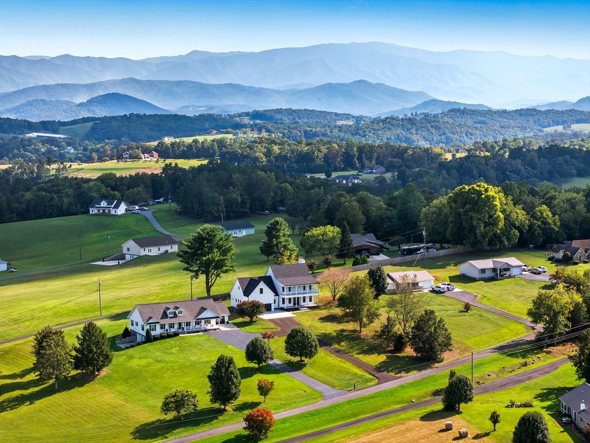 Aerial view of homes on rolling lawns with layered Smoky Mountain ridges behind, Newport TN
