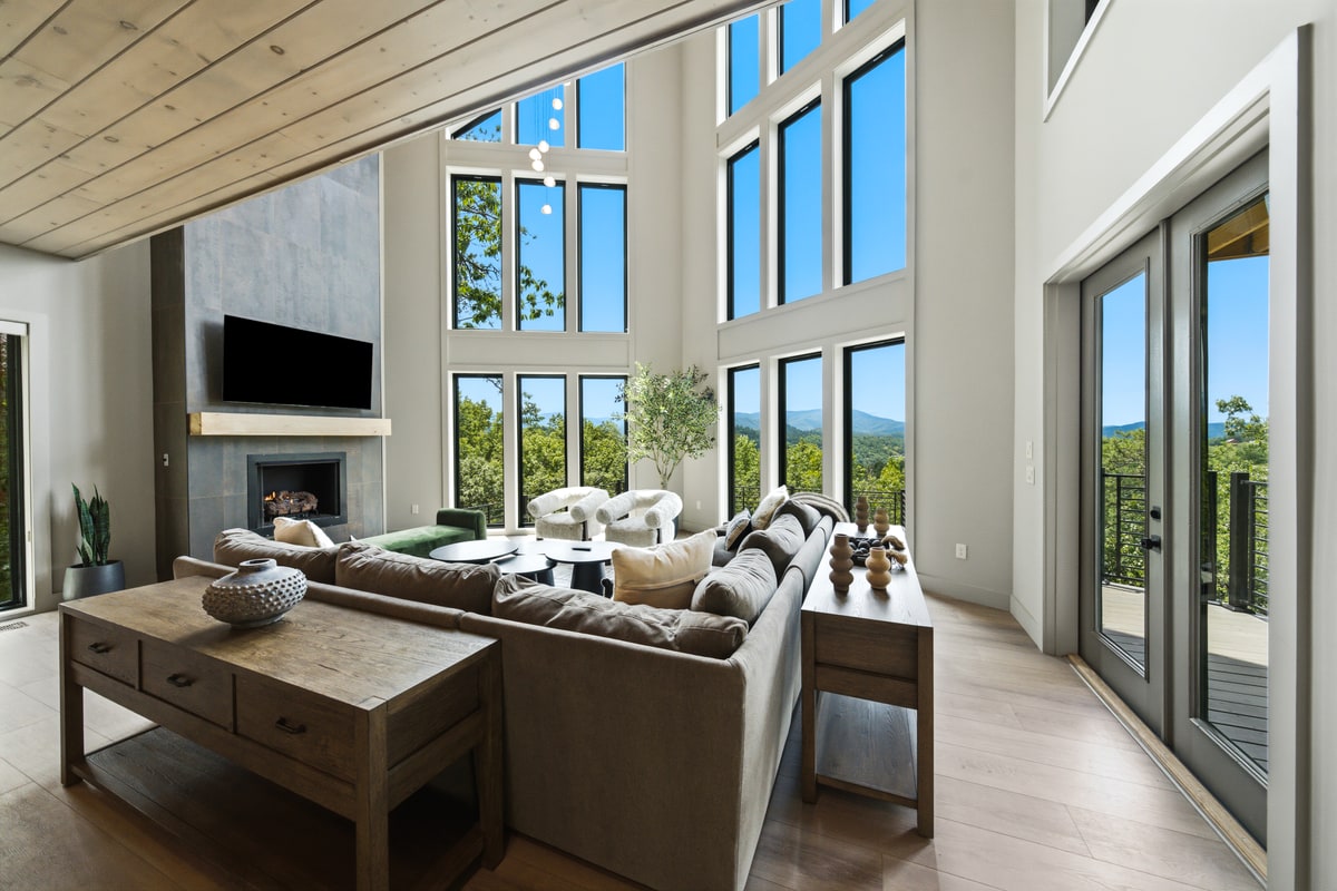 Two story living room with a fireplace, sectional sofa and a window wall with mountain views, Sevierville TN