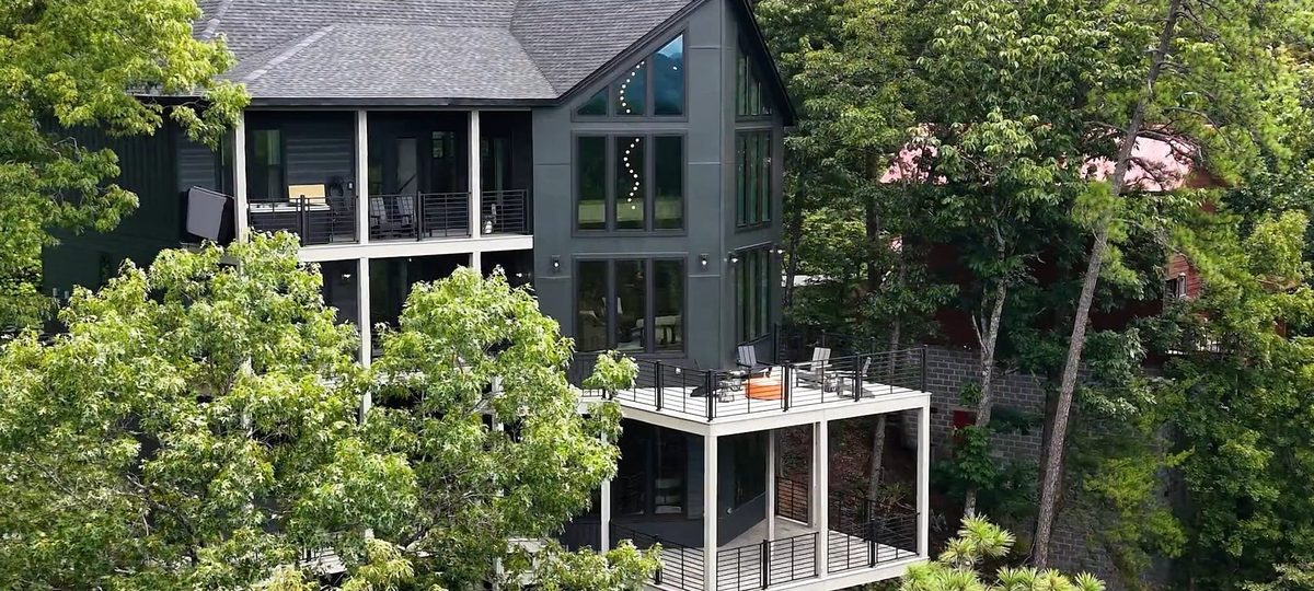 Aerial view of a mountain home with a wraparound deck in the trees, Sevierville TN